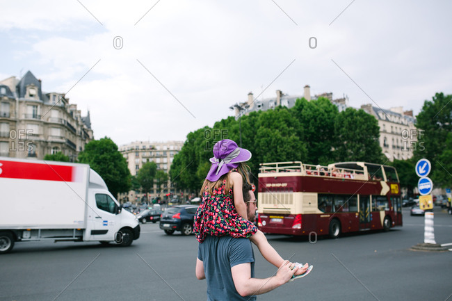 A girl on dad\'s shoulders in Paris