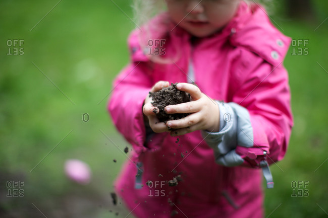 Girl trying to make mud ball