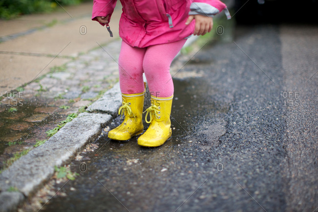 A girl in rain boots at roadside