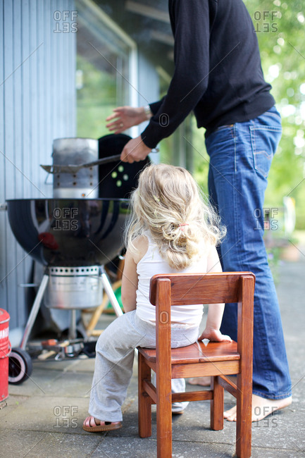 Little girl with father grilling out