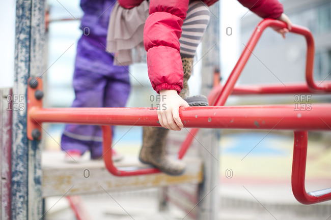 Girls climbing metal structure at playground