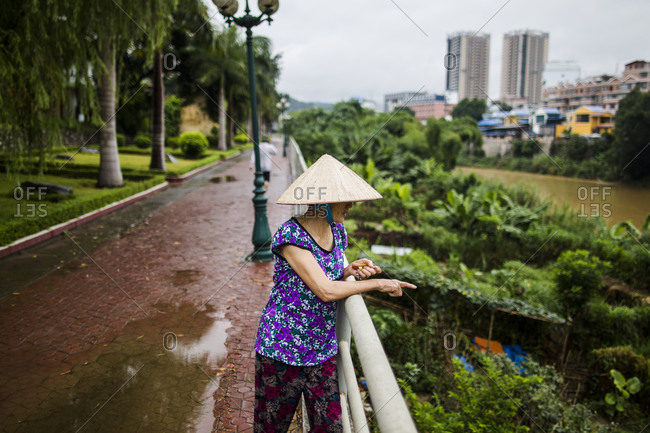 A Vietnamese woman gazes over small family farm plots set up against the river that borders Vietnam and China, in Lao Cai
