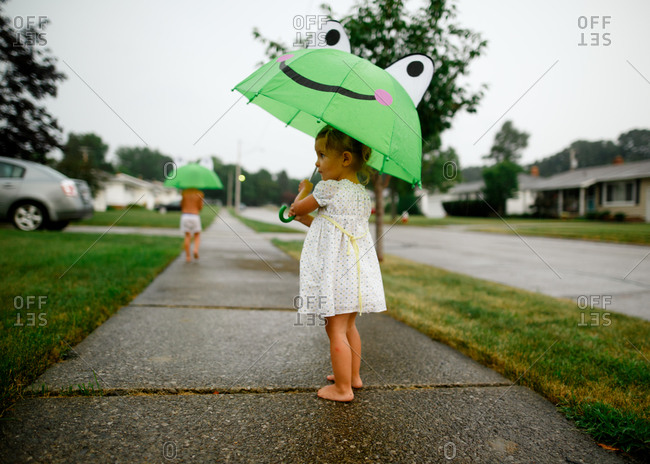 Children with umbrellas playing in the rain