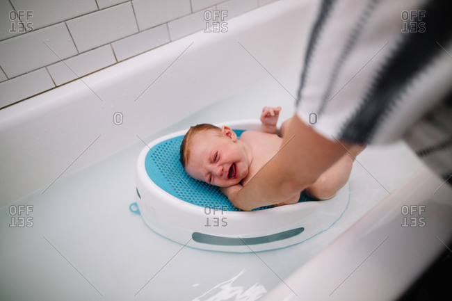 Baby cries in reaction to his bath
