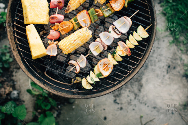 Various fruits and veggies on skewers on grill