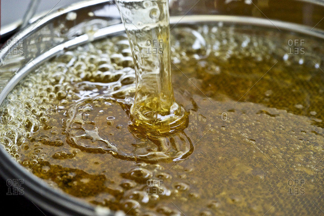 Fresh honey being poured through a sieve