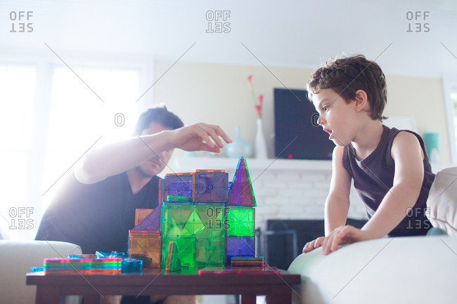 Boy and father building a castle with plastic blocks