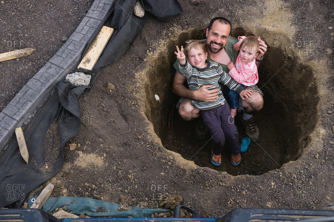 A family plays in a hole in their yard