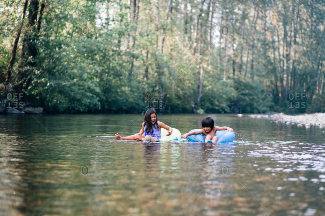 Boy and girl on inner tubes on a river