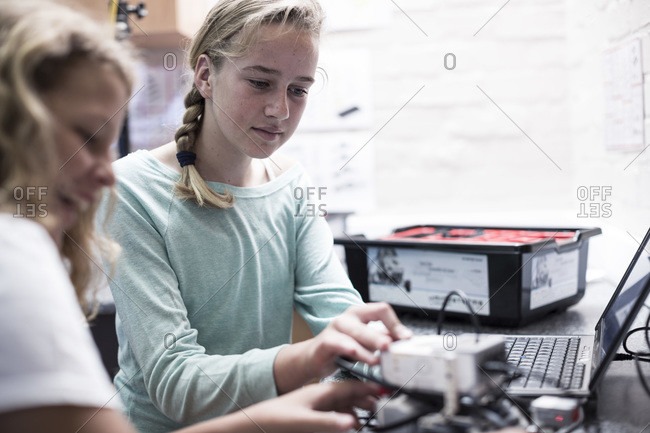 Two schoolgirls with laptop in robotics class