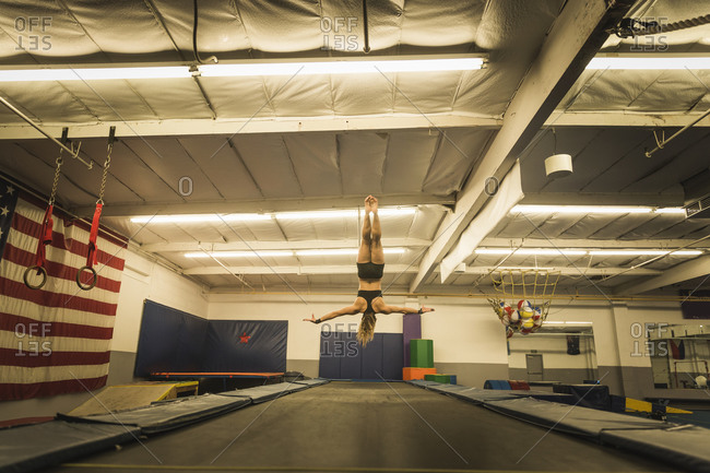 A gymnast flips upside-down