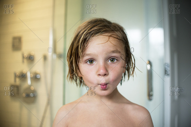 Portrait of boy in bathroom making fish face