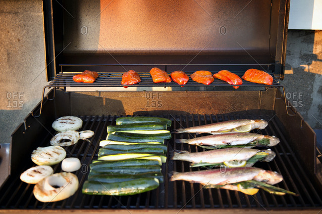 Stuffed fish and veggies on a grill