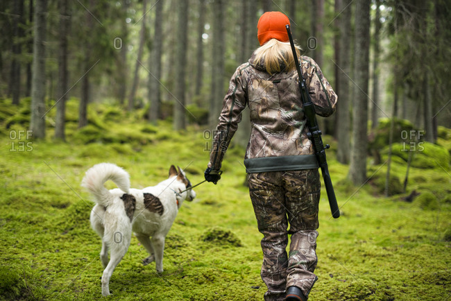 Woman with hunting dog in forest