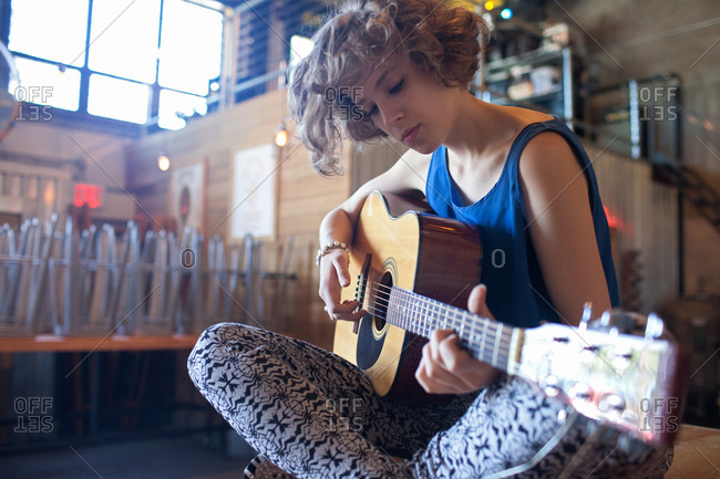 Young woman playing an acoustic guitar