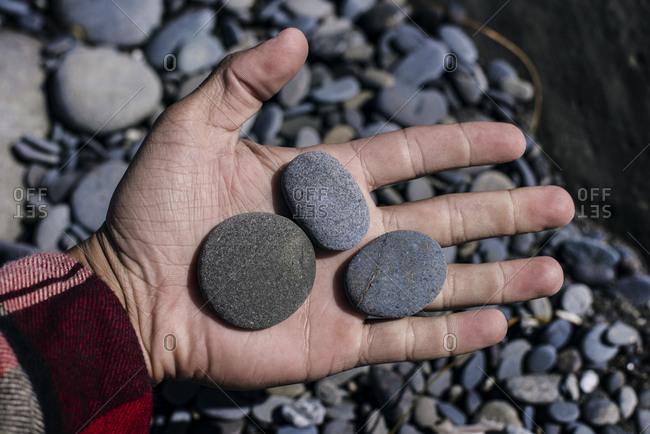 Man's hand displaying smooth stones