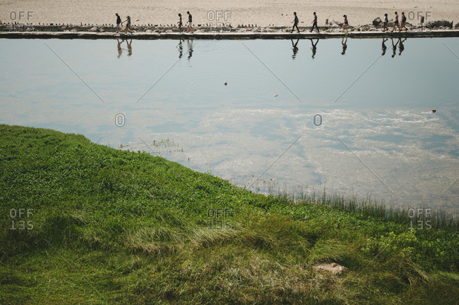 Visitors reflected in water of Sutro Baths as seen from the hill above