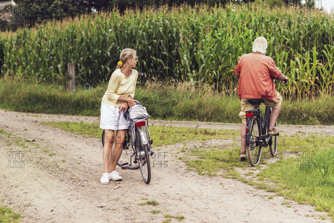 Retired senior couple with bikes near a corn field
