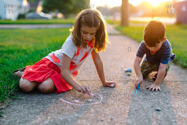 Kids drawing on sidewalk with chalk together