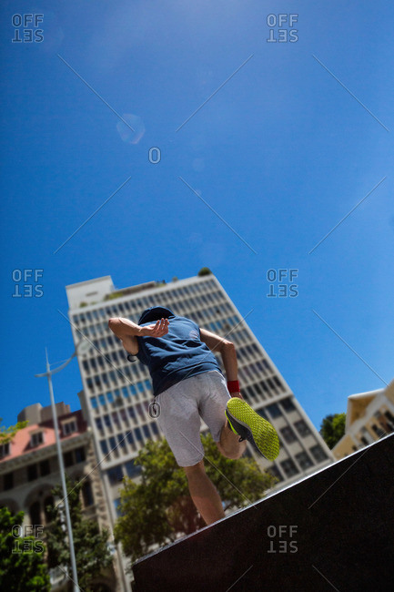 Man doing parkour in the city on a sunny day