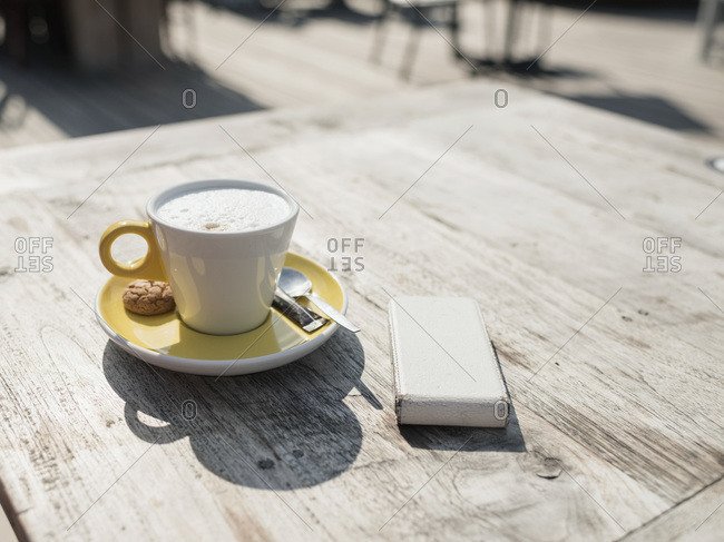 Coffee and cellphone on an outdoor table