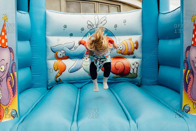 Little girl playing on an inflatable bounce house
