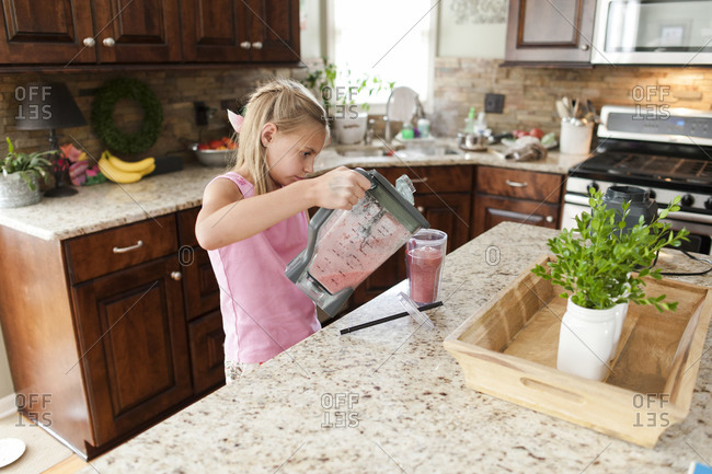 Girl pouring a smoothie into a glass