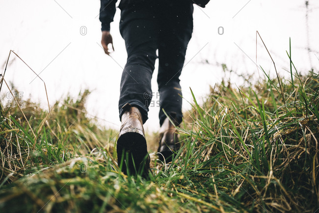 Man hiking through tall grass in leather boots