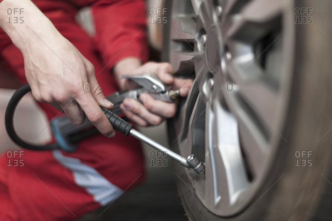 Close up of a mechanic adding air to a tire