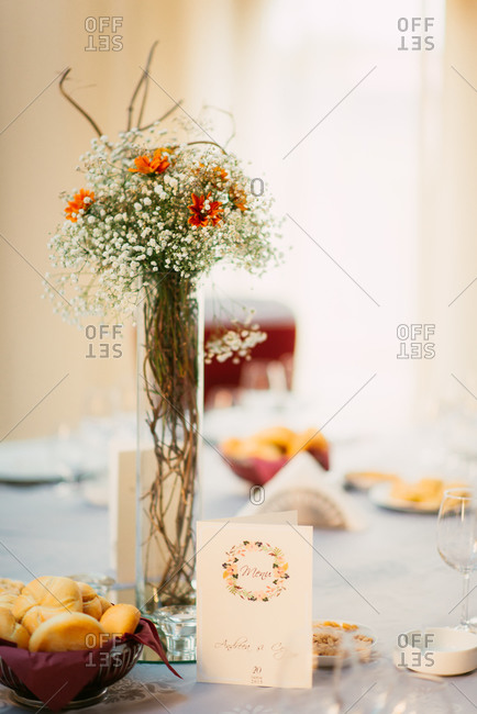 Bouquet of flowers and table set for wedding reception