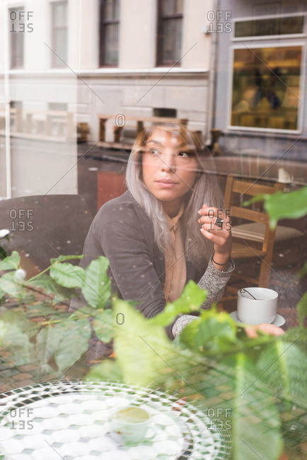 Woman staring out the window of a coffee shop
