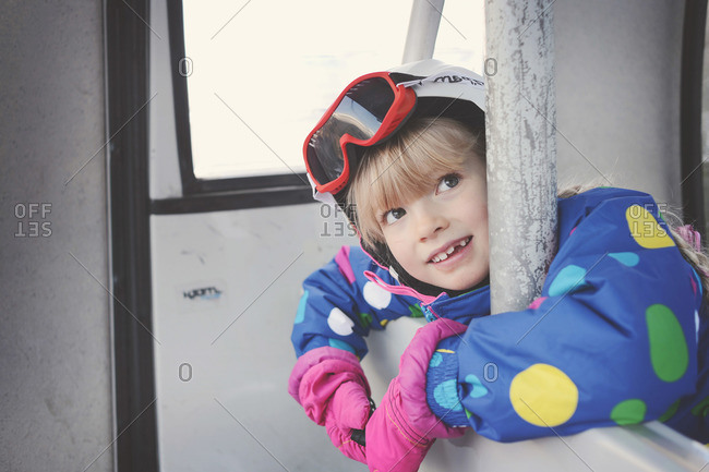 Young child leaning on side of ski gondola