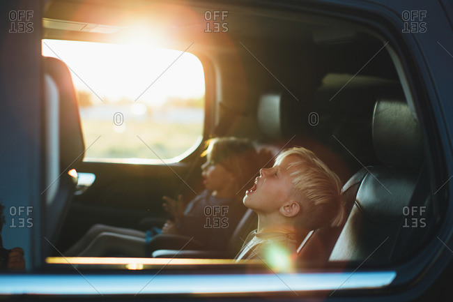 Two boys singing in back of car