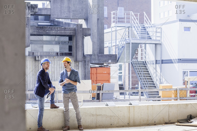 Two men on construction site wearing hard hats