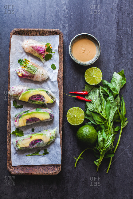 Tray of transparent vegetable Vietnamese summer rolls with peanut dipping sauce