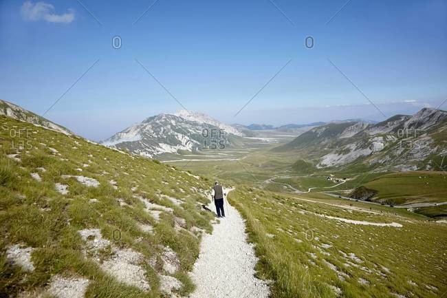 Man hiking on mountain trail, Gran Sasso mountain, Gran Sasso and Monti della Laga National Park, Apennines, Abruzzo, Italy