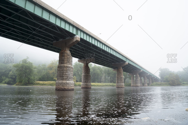 Bridge spanning river in mist