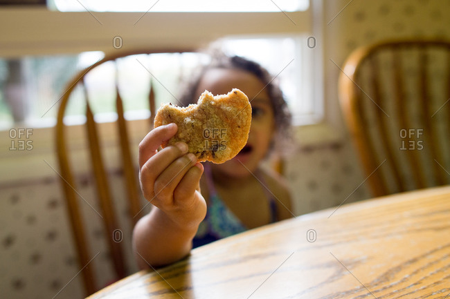 Little girl holding her partially eaten cookie