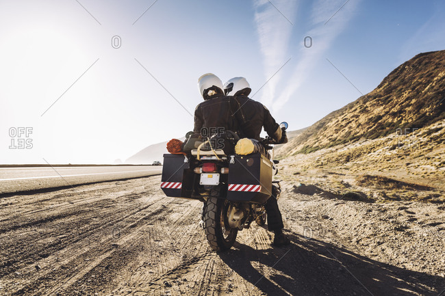 Couple on a motorcycle stop on side of the road
