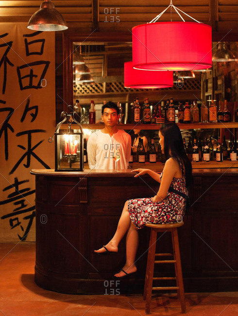A woman drinks a glass of wine hotel bar, Langkawi, Malaysia