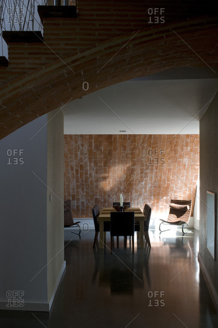 Open plan dining room and exposed brick staircase in a zero carbon house