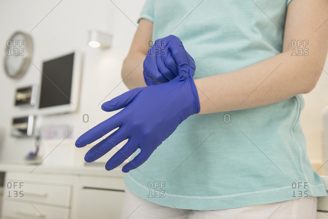 Dental assistant putting on gloves