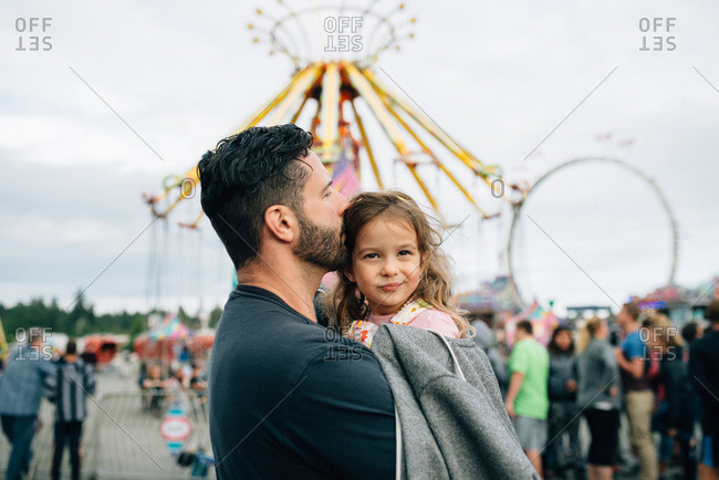 Father carrying his daughter at a fair