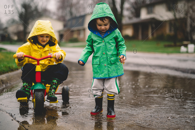 Little boys playing in puddles in the rain