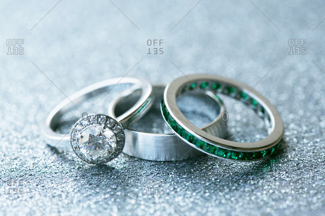 Close-up of engagement and wedding rings on silver surface