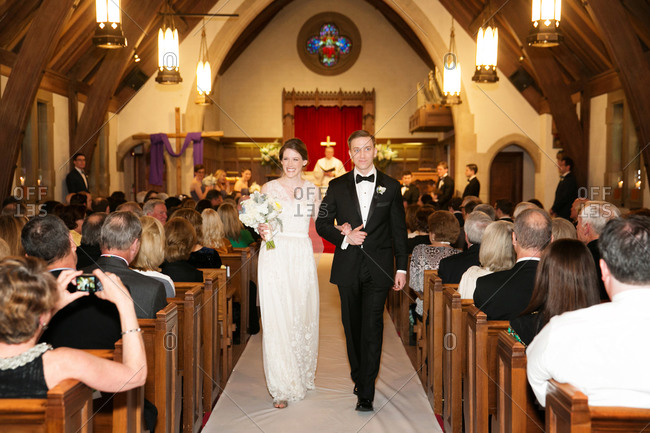 Bride and groom walking down the center aisle of church after ceremony