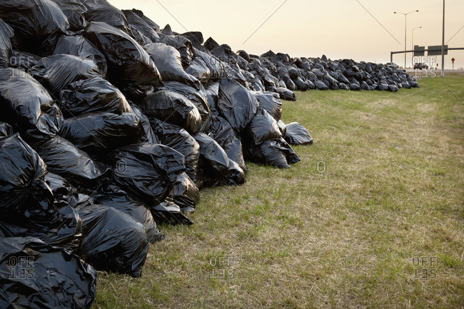 Hundreds of full black garbage bags along the Anthony Henday Highway, Edmonton, Alberta, Canada