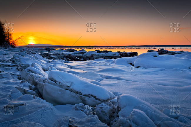 Sunset at Knik Arm in winter, with frozen coast in the foreground, Chugiak, Alaska, United States of America