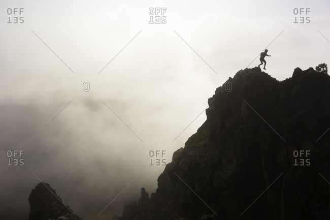 Man silhouetted by clouds while hiking