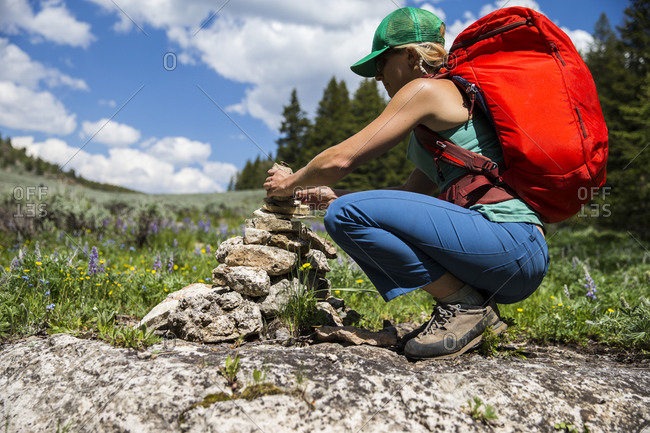 A woman builds a pile of rock to mark the trail Ten Sleep, Wyoming